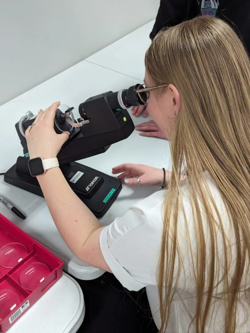 A woman looking through the lens of a camera.