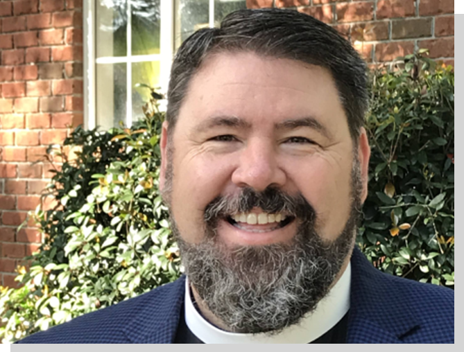 A man with a beard and mustache wearing a suit.