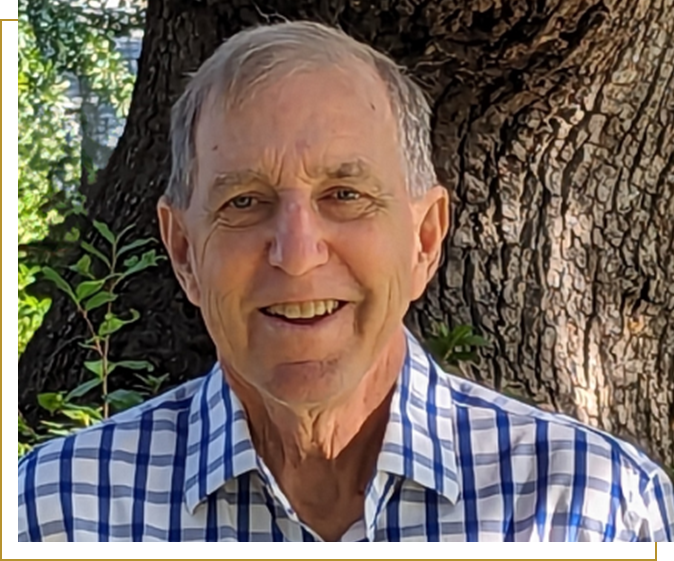 A man in plaid shirt next to tree.