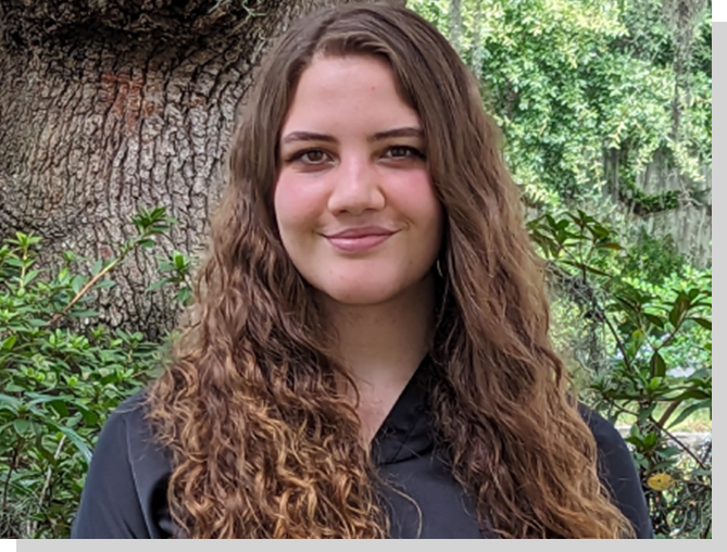 A woman with long hair and a black shirt.