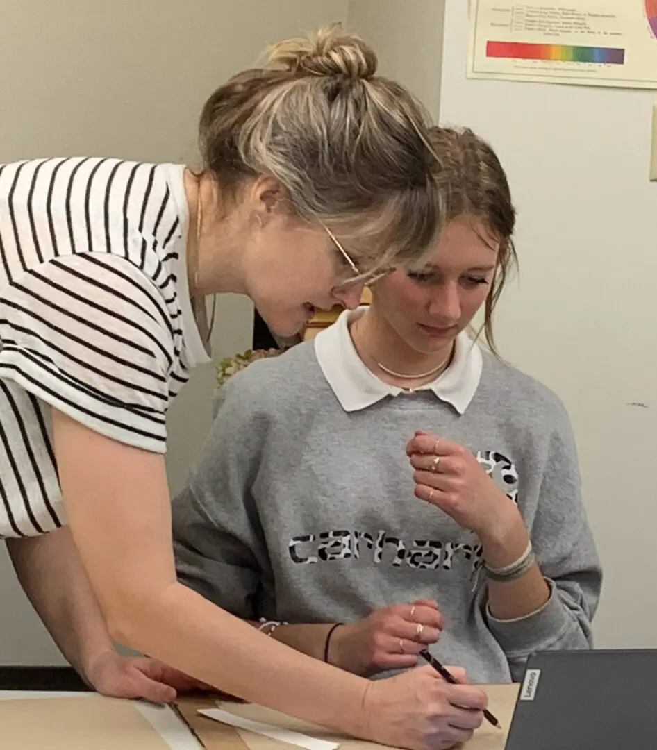 A woman and girl are looking at something on the table.