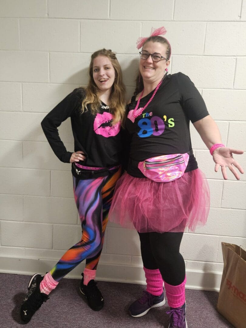 Two women dressed up in 8 0 's costumes