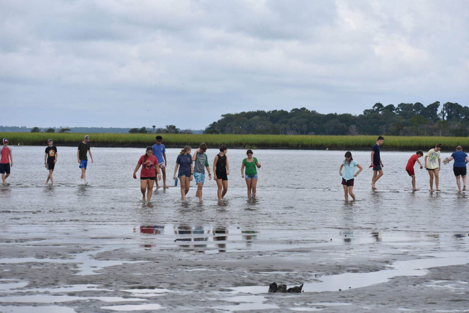 A group of people standing in shallow water.