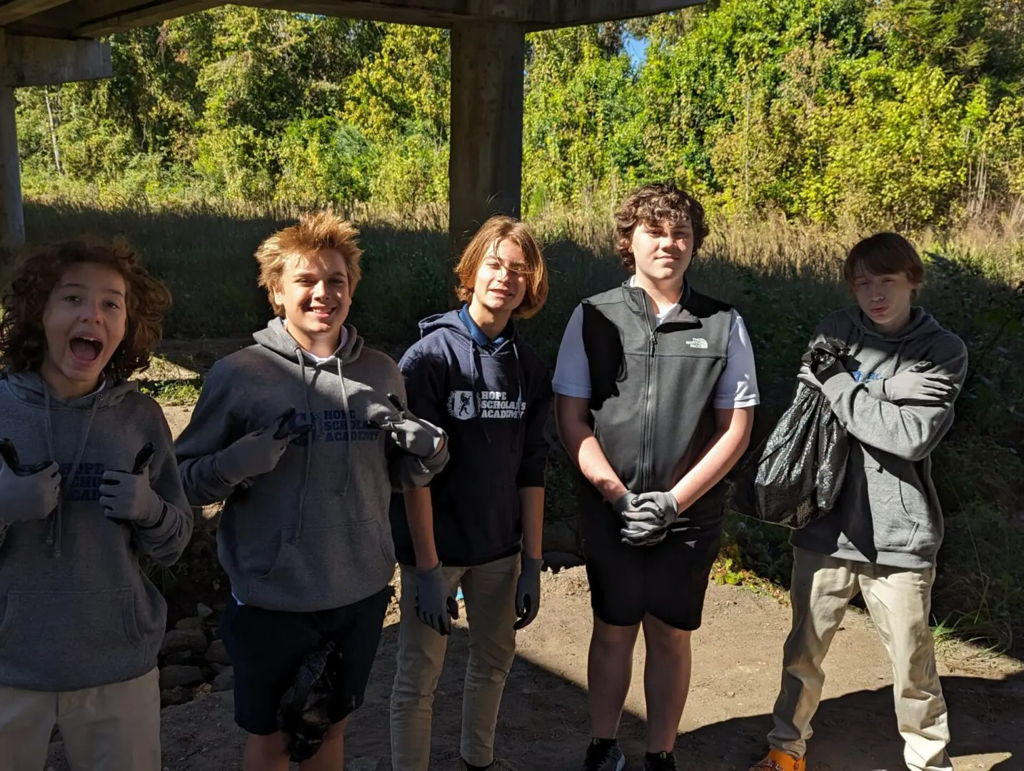 A group of people standing under an arbor.