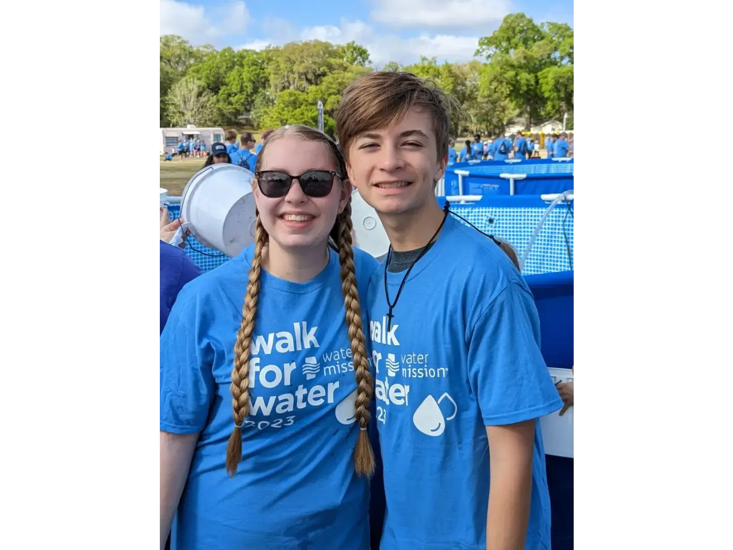 Two people in blue shirts standing next to each other.