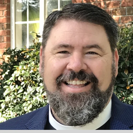 A man with a beard and mustache wearing a suit.