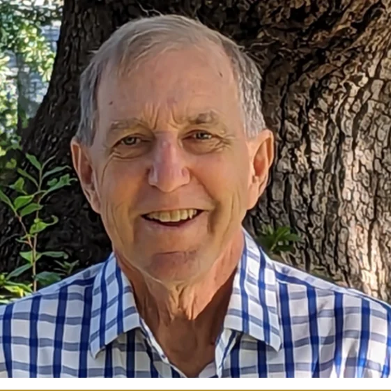 A man in plaid shirt next to tree.