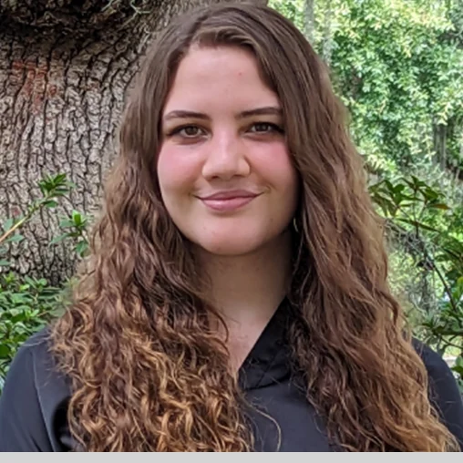 A woman with long hair and a black shirt.